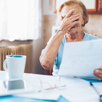 Elderly woman looking at her utility bills